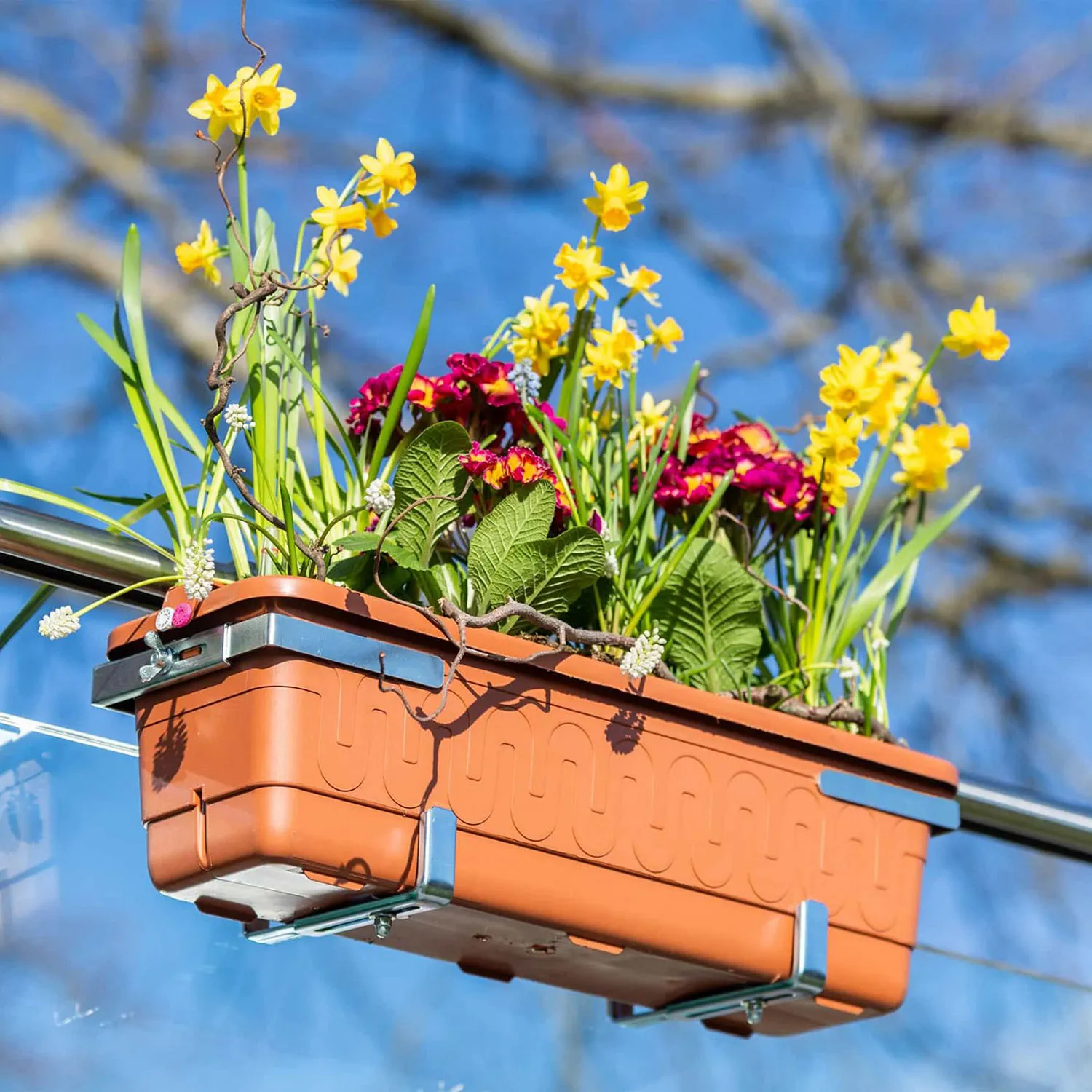 Blumenkasten mit Frühlingsblumen am Geländer, gesichert mit KOMBI-GRIP