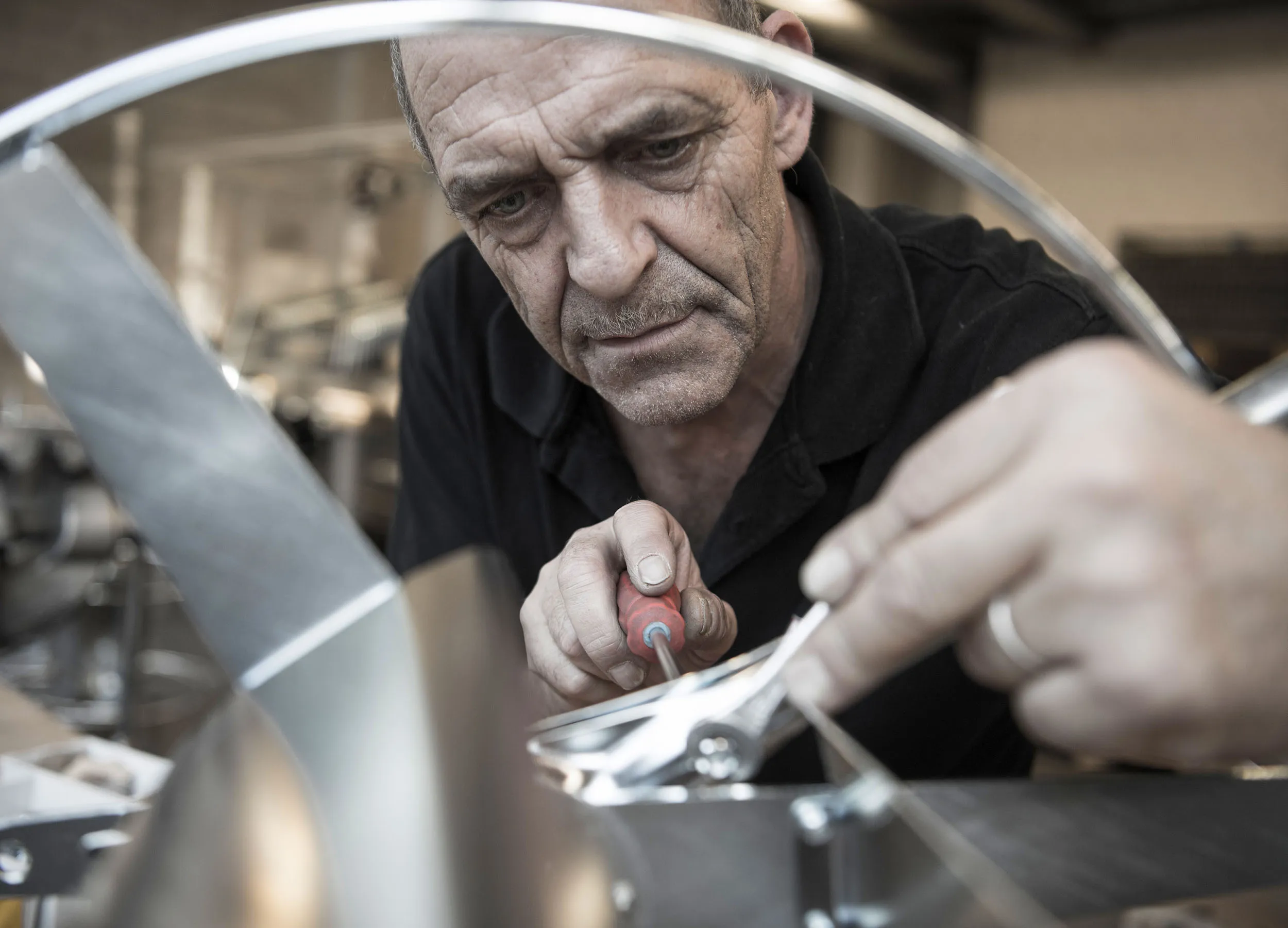 Experienced ALBA KRAPF employee assembling a steel device in the workshop