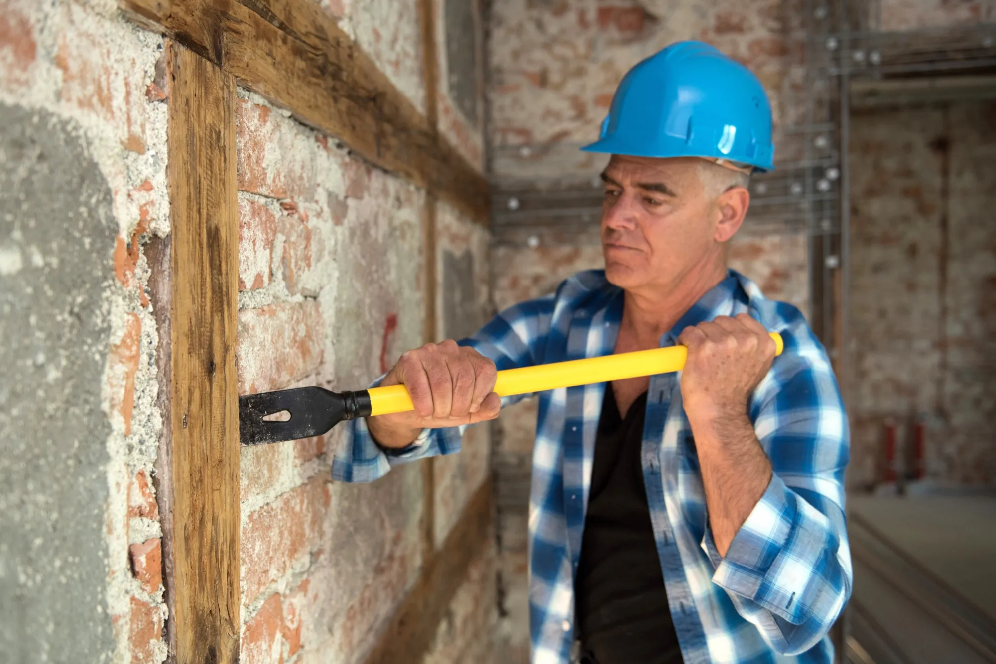 Murxli formwork stripping bar prying a wooden batten from a brick wall